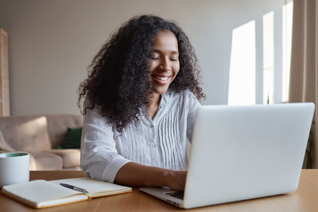 打字技术 职业 自由职业者和网络概念迷人的年轻黑皮肤的女性营销专家在远离家庭办公室的地方工作 在笔记本电脑上打字 做笔记和喝咖啡笔记本电脑阅读非洲