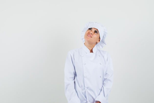 制服身着白色制服的女厨师抬起头 看上去充满希望举行美食工业