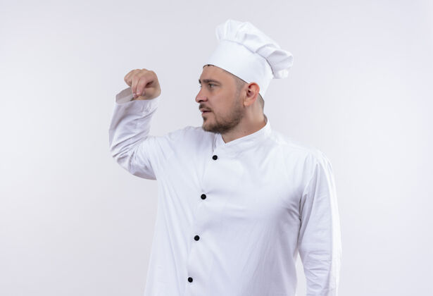 厨师年轻帅气的厨师身着厨师制服 一边看着撒盐一边隔离在白色的空间里看起来侧制服