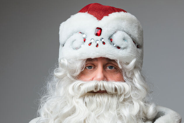 节日戴着红帽子的圣诞老人的头像 白发胡子的疲倦的男人服装圣诞老人累了