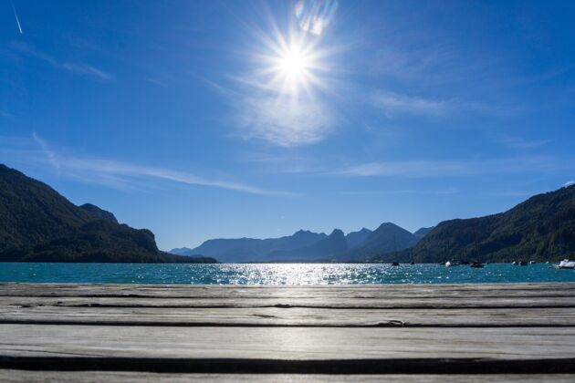 蓝色美丽的风景 灿烂的阳光照耀在沃尔夫冈西湖在斯特罗布尔奥地利绿松石房子阿尔卑斯山