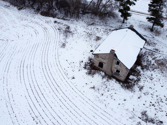 土地空中拍摄的一个农村的房子与领域覆盖着雪田野覆盖冰冻