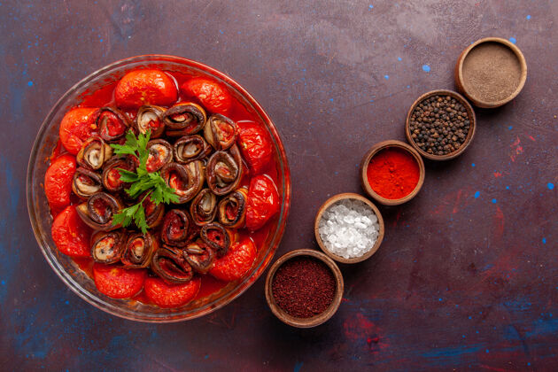 香料顶视图熟蔬菜餐西红柿和茄子卷和调味品在黑暗的桌子上煮卷番茄扣件