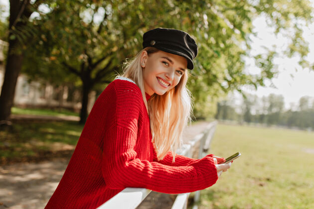 性感开朗的女孩微笑着 在公园里玩得很开心漂亮的金发女郎穿着漂亮的红色季节性服装肖像裙子女人