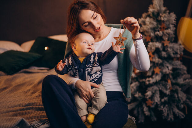 快乐妈妈带着她的男婴庆祝圣诞节节日妈妈女性