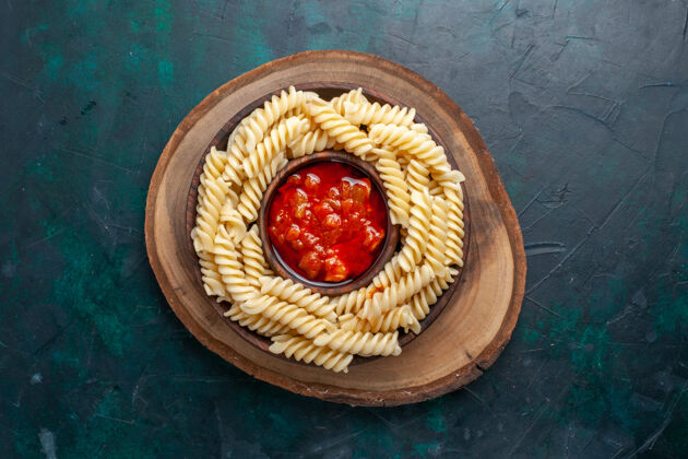 意大利顶视图形状意大利面食连同番茄酱深蓝色背景面团食物水果
