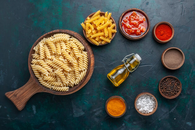 晚餐在深蓝色的桌子上俯瞰着意大利面食 里面有酱汁和调味品调味品面食食品