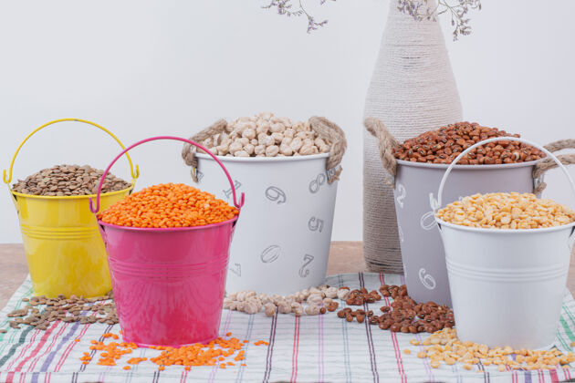 豌豆把各种各样的豆子放在五颜六色的桶里粮食干的花瓶