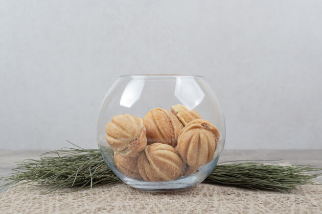 饼干胡桃形饼干放在粗麻布上的玻璃碗里自制植物粗麻布