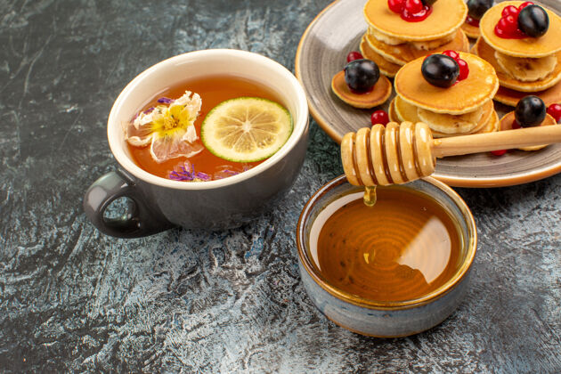 餐厅特写镜头的经典美国煎饼与蜂蜜和一杯茶健康营养杯子