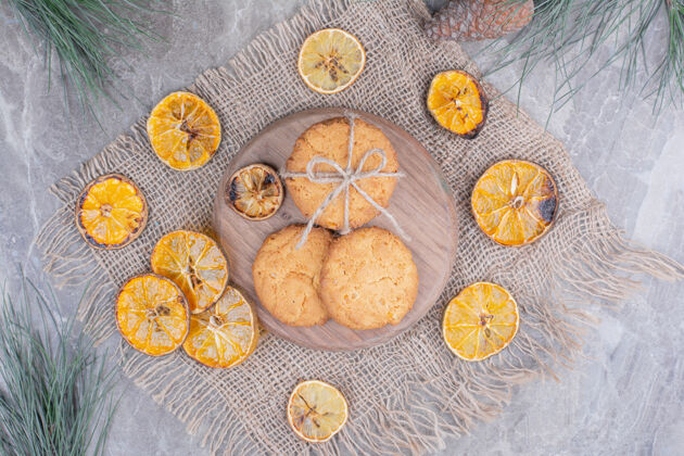 圆锥形荷兰华夫饼和饼干放在木板上 周围是干橘子片面包房零食喜悦