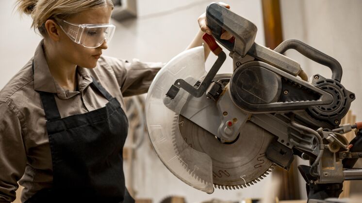 工人带工具和眼镜的女木匠侧视图职业工作技能