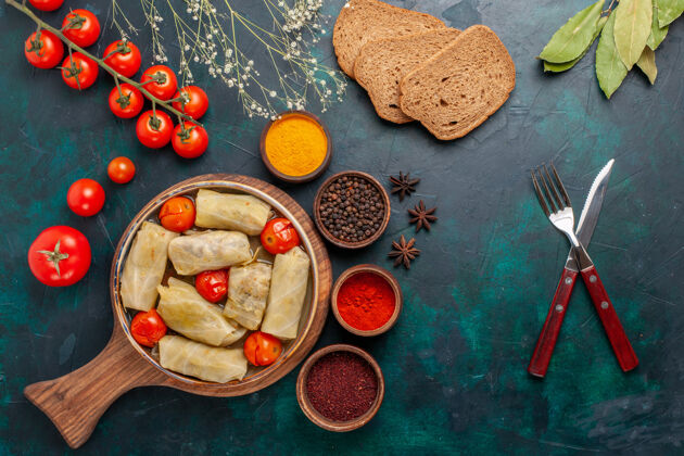 食物俯瞰图美味的肉食卷心菜内卷面包和新鲜西红柿在深蓝色的桌子上早餐蔬菜一餐