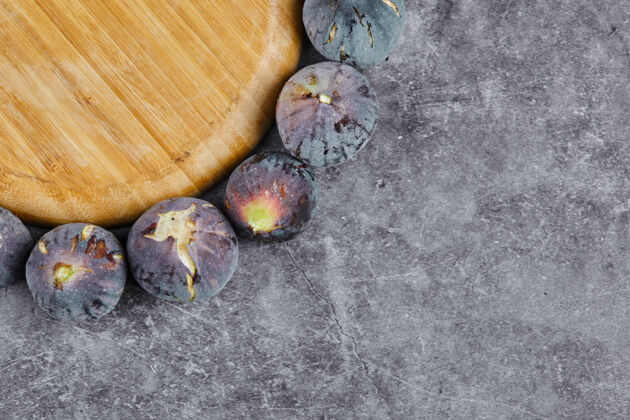 视图紫色无花果围绕在大理石的木板上种子无花果有机