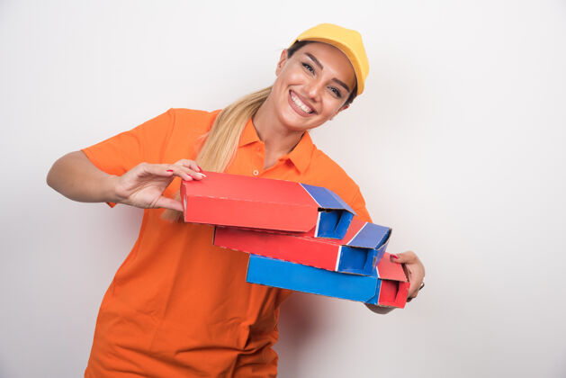 大笑一个戴着黄色帽子的女送货员拿着比萨饼盒在空白处人用餐披萨