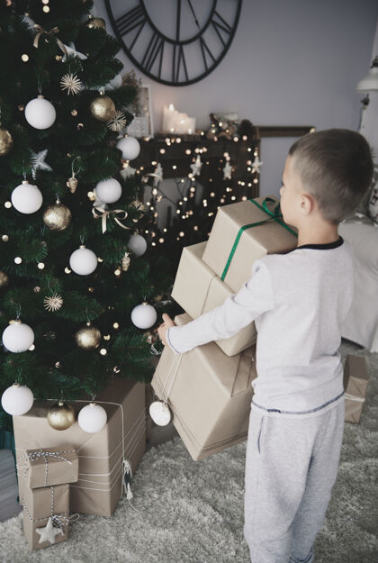 采取孩子把礼物放在圣诞树下安排乐趣圣诞树