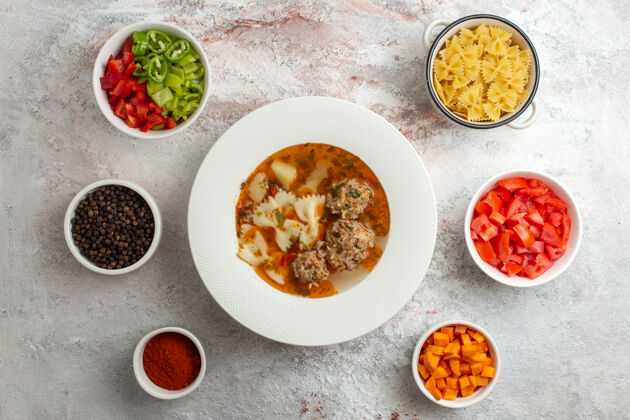 背景顶视图肉汤美味的汤与切片蔬菜和调味料的白色背景盘子餐美味