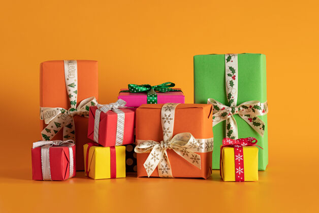 丝带橙色背景的多色礼品盒特写 圣诞气氛五颜六色装饰圣诞节