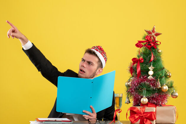 工人正面图男性工人坐在黄色的椅子上拿着文件工作圣诞节年
