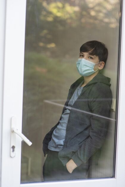 冠状病毒男孩透过窗户向外看隔离Ncov检疫