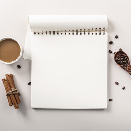 饮料平铺的笔记本和咖啡杯和肉桂棒平板杯子顶部