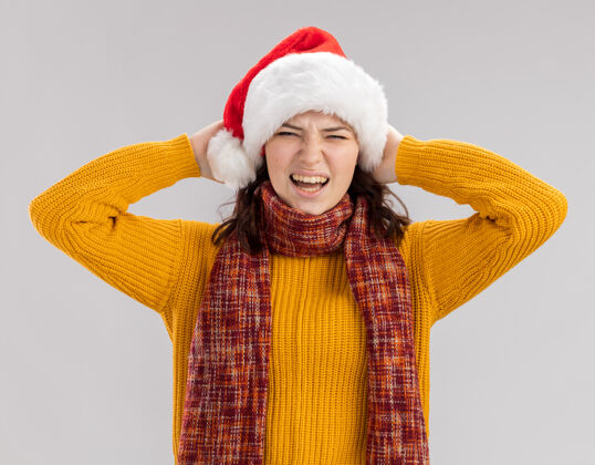 快乐戴着圣诞帽 脖子上围着围巾的未被释放的年轻斯拉夫女孩把头孤立地放在白色背景上 留有复制空间头圣诞节持有