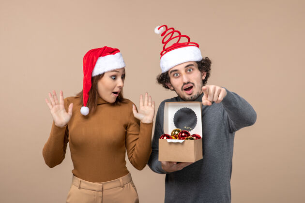 节日喜庆的心情与兴奋酷夫妇戴着红色圣诞老人帽家伙打开博克森灰色镜头成人圣诞老人圣诞节