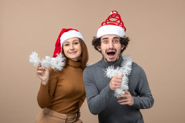圣诞老人新年气氛喜庆概念搭配酷酷可爱情侣戴着红色圣诞老人帽的灰色形象心情帽子可爱的情侣