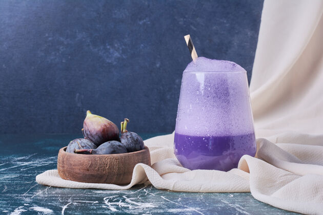 质量紫色的无花果配一杯蓝色的饮料水果热美味