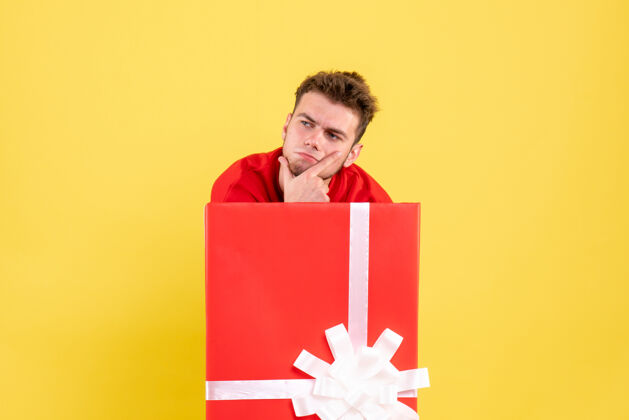 站着正面图穿红衬衫的年轻男子站在礼品盒内笔记本雪衬衫