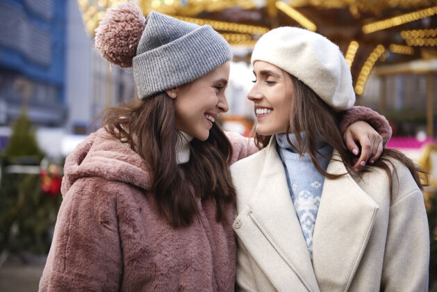 游客圣诞集市上的两位女性挚友圣诞姐妹公平