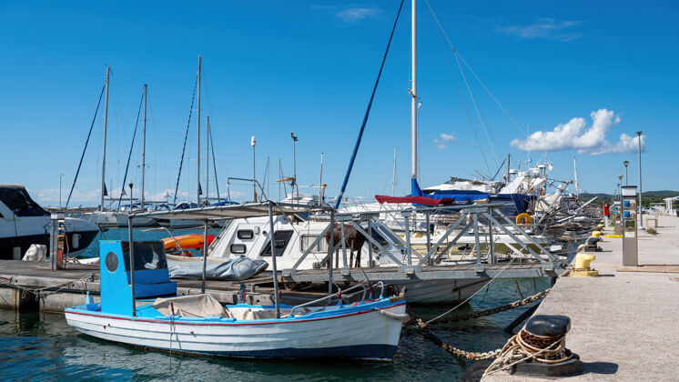 希腊爱琴海海港有多艘停泊的游艇和船只 希腊尼基提天气晴朗红色海滩海岸