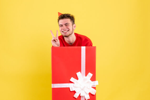 年轻正面图：礼品盒内穿红色衬衫的年轻男性男性购物雪