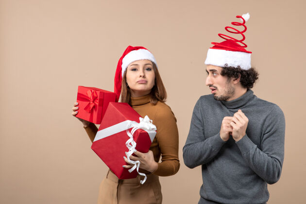 心情新年气氛喜庆的概念与搞笑酷可爱的情侣穿着灰色的红色圣诞老人帽帽子圣诞老人节日