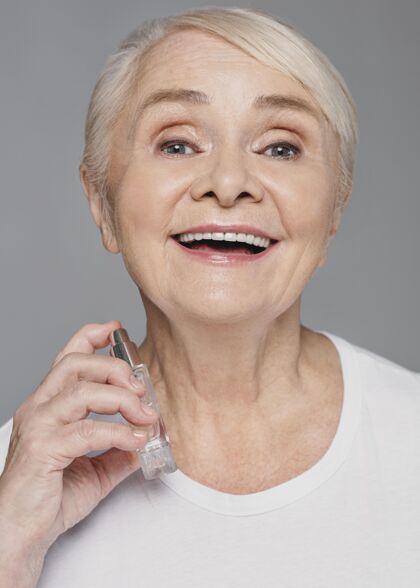 护理特写笑脸女人用香水老年人灰色老年人
