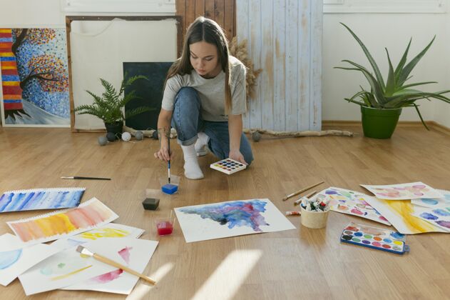 艺术家远射的女人在地板上画画绘画绘画艺术