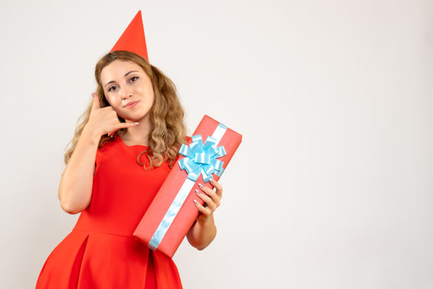 成人正面图身着红色连衣裙的年轻女性用礼物庆祝圣诞节美丽庆祝夏娃