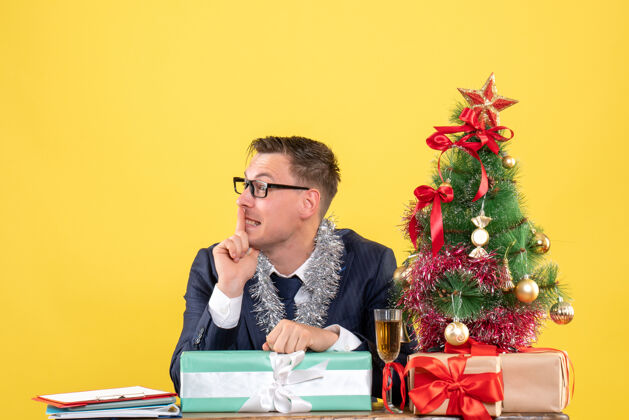 商人圣诞树旁的桌子旁摆着一个“快乐男人”的嘘牌 黄色的礼物礼物黄色坐着