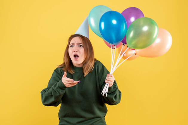 气球正面图是一位年轻的女士 手里拿着五颜六色的气球乐趣快乐聚会