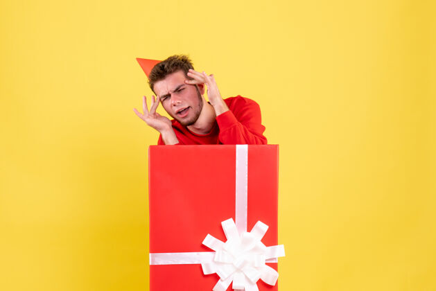 生日正面图：礼品盒内穿红色衬衫的年轻男性内部男性丝带