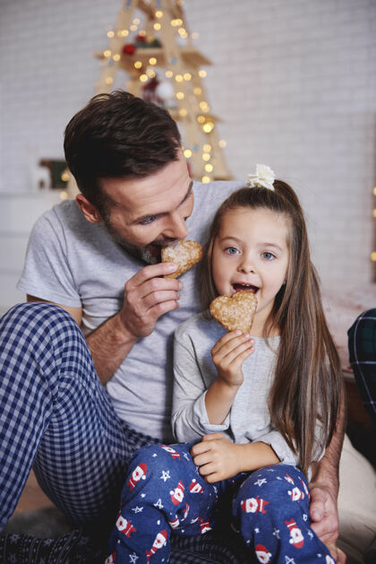 开朗爸爸和女儿在圣诞节吃姜饼吃邦德甜点