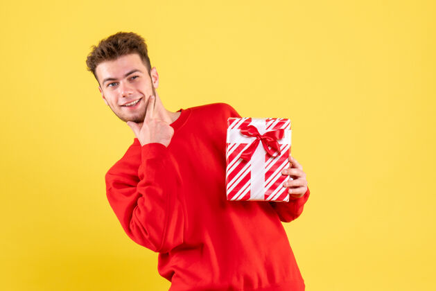 红色正面图：穿着红色衬衫的年轻男性 带着圣诞礼物成人情感人