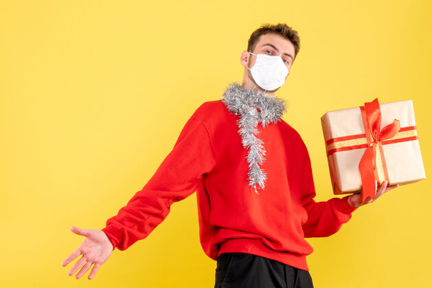 礼物正面图：戴着无菌面具的年轻男性正在过圣诞节Covid成人服装