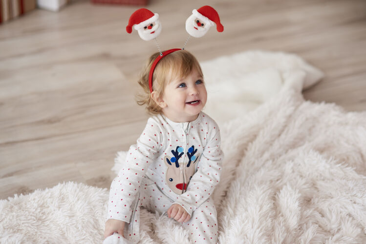 家里圣诞节早晨可爱的宝贝圣诞装饰品女婴地板