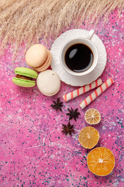 观顶视图一杯茶 粉红色桌上放着法国马卡龙蛋糕饼干甜甜的糖派饼干顶面子