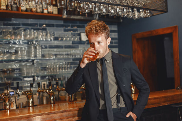 啤酒一个穿黑西装的男人喝酒一个漂亮的男人喝一杯威士忌表情威士忌酒吧