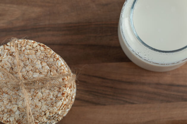 开胃菜在木板上放一杯牛奶和脆面包干的谷物牛奶