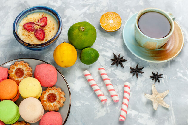 水果俯瞰美味的法国马卡龙饼干甜点和茶在浅白的桌子上烤蛋糕饼干糖甜的照片生的维生素顶部