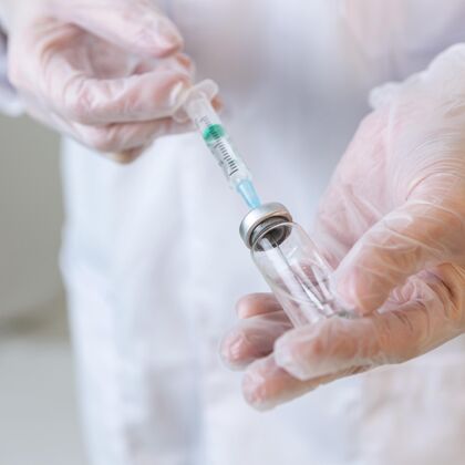研究员女研究员戴着手套拿着注射器的特写镜头疫苗化学创新者