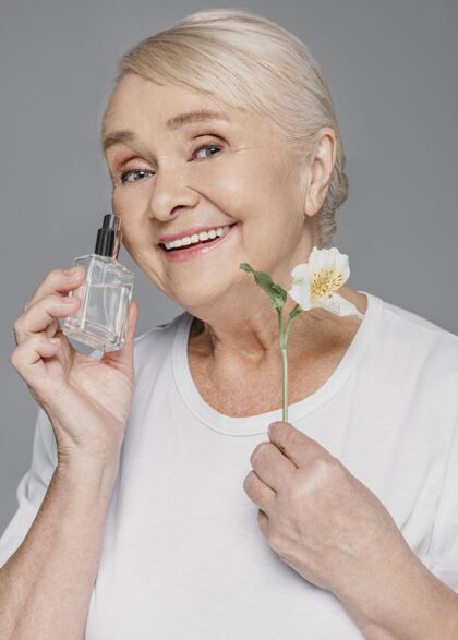 垂直拿着花和瓶子的中枪女人生活方式自我护理老年人